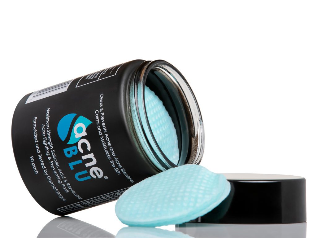 Acne BLU jar opened with blue medicated acne and blemish pads or wipes pulled outside
