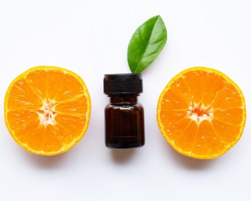 Essential oil with fresh orange citrus fruit on a white background