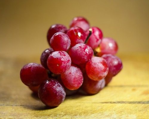 Red grapes on a wood surface